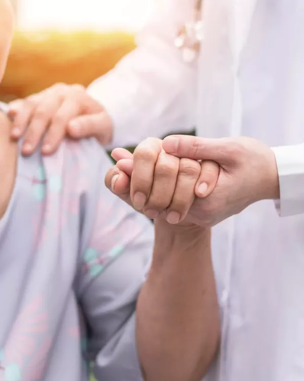 hospice worker holding patient's hand